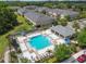 An aerial view reveals a pristine community pool area with lounge chairs and a covered pavilion at 5833 Grand Sonata Ave, Lutz, FL 33558