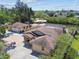 This aerial view showcases the property's mature trees, large yard, screened lanai and convenient boat dock at 6732 Udell Ln, Hudson, FL 34667