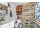 Pool bathroom featuring unique brick wall and functional utility sink at 6732 Udell Ln, Hudson, FL 34667