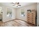 This cozy bedroom features wood-look floors, light-colored walls, and two windows with wood trim for natural light at 6732 Udell Ln, Hudson, FL 34667