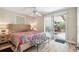 This bright bedroom has a sliding glass door to a screened patio, light walls, and wood-look flooring at 6732 Udell Ln, Hudson, FL 34667