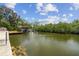 Water view showing a private boat lift and dock in a serene, green waterway at 6732 Udell Ln, Hudson, FL 34667