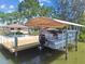 Covered boat lift on a private dock, with a view of the waterfront home at 6732 Udell Ln, Hudson, FL 34667