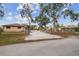 Charming home featuring a long driveway, secured gate, and lush mature trees at 6732 Udell Ln, Hudson, FL 34667