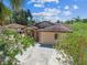 Exterior view of home featuring brick accents, a well-maintained roof, and mature landscaping at 6732 Udell Ln, Hudson, FL 34667