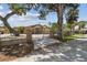 Home entrance with wrought iron gate, lush trees, and secure brick columns at 6732 Udell Ln, Hudson, FL 34667