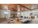 Spacious living room features a wood-paneled ceiling, brick fireplace, and comfortable seating, with a view into the kitchen at 6732 Udell Ln, Hudson, FL 34667