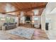 Inviting living room with wood-paneled ceiling, brick fireplace, and views of the dining area at 6732 Udell Ln, Hudson, FL 34667
