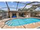 Inviting screened-in pool with brick accents and access to the home's interior at 6732 Udell Ln, Hudson, FL 34667