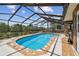 Relaxing screened-in pool area with beautiful tile work and surrounding greenery at 6732 Udell Ln, Hudson, FL 34667