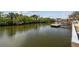 Scenic waterfront view featuring calm water with lush green trees and a private dock, perfect for boating at 6732 Udell Ln, Hudson, FL 34667