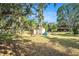 Large backyard featuring a shed, picnic table, garden with mature trees and abundant greenery at 7157 Quail Hollow Blvd, Wesley Chapel, FL 33544