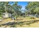 Well-maintained backyard featuring a shed, sprinkler system, garden and abundant greenery at 7157 Quail Hollow Blvd, Wesley Chapel, FL 33544