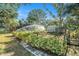 Fenced backyard featuring an active sprinkler watering raised garden beds, a shed, and green foliage at 7157 Quail Hollow Blvd, Wesley Chapel, FL 33544