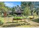 Charming backyard featuring raised garden beds and a glimpse of the house in a serene, wooded setting at 7157 Quail Hollow Blvd, Wesley Chapel, FL 33544