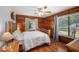 Bedroom featuring wood paneling, natural light from two windows, and a ceiling fan at 7157 Quail Hollow Blvd, Wesley Chapel, FL 33544