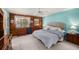 Comfortable bedroom featuring wood paneling, a plush bed, and ample natural light at 7157 Quail Hollow Blvd, Wesley Chapel, FL 33544