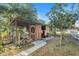 A well-maintained chicken coop with enclosed mesh and access door surrounded by green grass and trees at 7157 Quail Hollow Blvd, Wesley Chapel, FL 33544