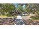 Charming home with a two-car garage and long driveway nestled among beautiful mature trees at 7157 Quail Hollow Blvd, Wesley Chapel, FL 33544