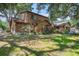 Beautiful log cabin home featuring lush green lawns and mature trees at 7157 Quail Hollow Blvd, Wesley Chapel, FL 33544