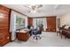 Office space featuring wood paneling, a ceiling fan, and natural light from the windows at 7157 Quail Hollow Blvd, Wesley Chapel, FL 33544