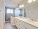 Bright bathroom features a double sink vanity with a glass enclosed tiled shower at 7501 S Morton St, Tampa, FL 33616