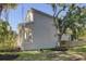 Side view of the home with white trim, a small seating area, a fence, and green landscaping at 7501 S Morton St, Tampa, FL 33616