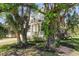 Beautiful two story home with a lush landscaped front yard, plants, and mature trees at 7501 S Morton St, Tampa, FL 33616