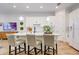 Bright kitchen island with bar stool seating, a sink, and modern lighting fixtures overhead at 7501 S Morton St, Tampa, FL 33616