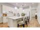 Bright kitchen island with bar stool seating, a sink, and modern lighting fixtures overhead at 7501 S Morton St, Tampa, FL 33616