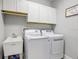 Well-lit laundry room with a washer, dryer, sink, and overhead cabinets at 7501 S Morton St, Tampa, FL 33616
