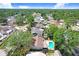 Aerial view of a neighborhood featuring homes with private pools and mature trees, showcasing a residential community at 7703 W Hiawatha St, Tampa, FL 33615