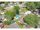 An aerial view of a home featuring a backyard pool and mature trees in a residential neighborhood at 7703 W Hiawatha St, Tampa, FL 33615
