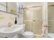 Simple bathroom features a white sink, toilet, and shower with sliding glass doors at 7703 W Hiawatha St, Tampa, FL 33615