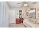 Bright bedroom featuring neutral walls, a ceiling fan, window, and a built-in dresser with a mirror at 7703 W Hiawatha St, Tampa, FL 33615