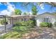 Charming single-story home featuring a large tree, two-car garage, and well-maintained landscaping at 7703 W Hiawatha St, Tampa, FL 33615