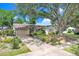 Charming single-story home featuring a large tree, two-car garage, and well-maintained landscaping at 7703 W Hiawatha St, Tampa, FL 33615