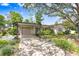 Charming single-story home featuring a large tree, two-car garage, and well-maintained landscaping at 7703 W Hiawatha St, Tampa, FL 33615