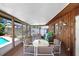 Relaxing screened-in patio features wood walls, a ceiling, and an outdoor dining set at 7703 W Hiawatha St, Tampa, FL 33615