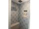 Modern tiled shower featuring stylish patterned tiles, a built-in niche, and a rainfall shower head at 7919 Causeway S Blvd, St Petersburg, FL 33707