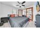 This bedroom offers wood floors, a fan, and an adjoining room with glass-paned doors at 8115 N Ola Ave, Tampa, FL 33604