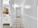 Clean hallway leading to bathroom with tile flooring and white walls at 8115 N Ola Ave, Tampa, FL 33604