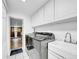 Bright laundry room featuring a new washer and dryer with ample cabinet space at 8115 N Ola Ave, Tampa, FL 33604