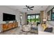 Comfortable living room with stylish decor, seamlessly blending into the dining space with a beautiful backyard view at 819 Steel Dr, Apollo Beach, FL 33572