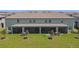 Scenic backyard with lush green lawn, screened lanai, and young trees at 8953 Gallantree Pl, Land O Lakes, FL 34637