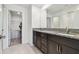 Bathroom featuring dual sinks, granite countertops, and a walk-in closet at 8953 Gallantree Pl, Land O Lakes, FL 34637