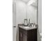 Modern bathroom features granite countertop vanity, dark cabinets, and a large mirror at 8953 Gallantree Pl, Land O Lakes, FL 34637
