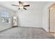 Bright bedroom with a window offering outdoor views, ceiling fan and neutral carpet at 8953 Gallantree Pl, Land O Lakes, FL 34637