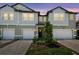 Charming townhome showcasing two-story facade, modern windows, well-kept landscaping, and private garages at 8953 Gallantree Pl, Land O Lakes, FL 34637
