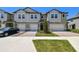Attractive townhome displaying brick driveway, manicured lawn, private garage, and appealing entrance at 8953 Gallantree Pl, Land O Lakes, FL 34637